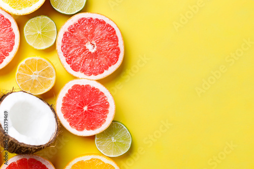 Summer vacation, cocktail, tropical beach. Composition with exotic fruits on yellow background. Summertime creative layout, copy space for text design