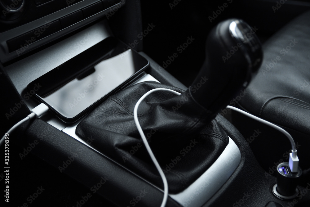 Obraz premium Mobile phone, smartphone charge battery, charging in the car plug close up