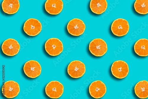 Colorful fruit pattern of Dekopon fresh orange slices on blue background, spring, summer cocept.