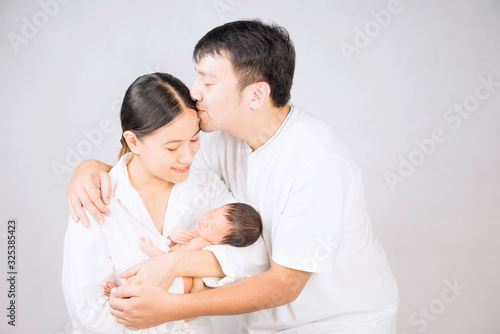 Parents carrying baby. portrait of young family with little son. selective focus of of happy young father kiss mother and hugging infant baby.