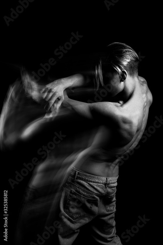 Naked back curves. Beautiful fuzzy mystical mysterious ambiguous original conceptual profile side portrait of young blonde man on a black background. Black and white photo series. long exposure