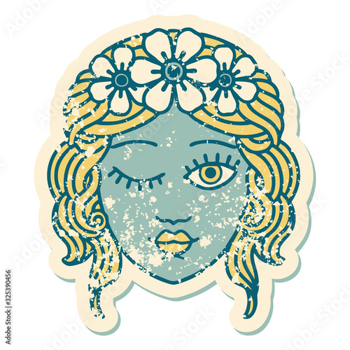 distressed sticker tattoo style icon of a maidens face winking