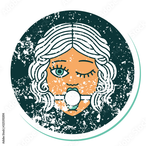 distressed sticker tattoo style icon of winking female face with ball gag