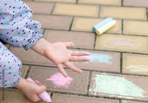 children's palm stained with pink chalk. chalk drawing on the sidewalk. art, creative education for children. soft focus
