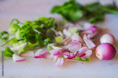 Shredded onnions, scallions, and celery leaves on white surface. © Fajri Hidayat