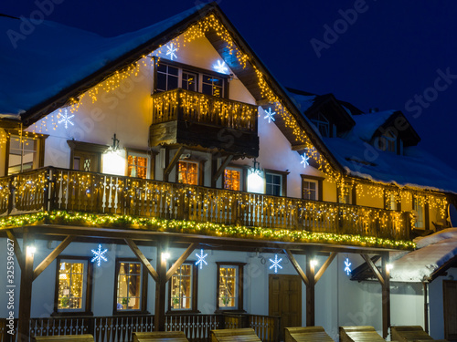 Ski resort Gornaya Salanga at night. Blue twilight is falling, a yellow cozy warm light has lit up in the houses. Winter in Siberia photo