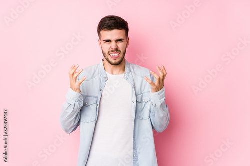 Young caucasian business man posing in a white background isolated upset screaming with tense hands.  mixto   © Asier