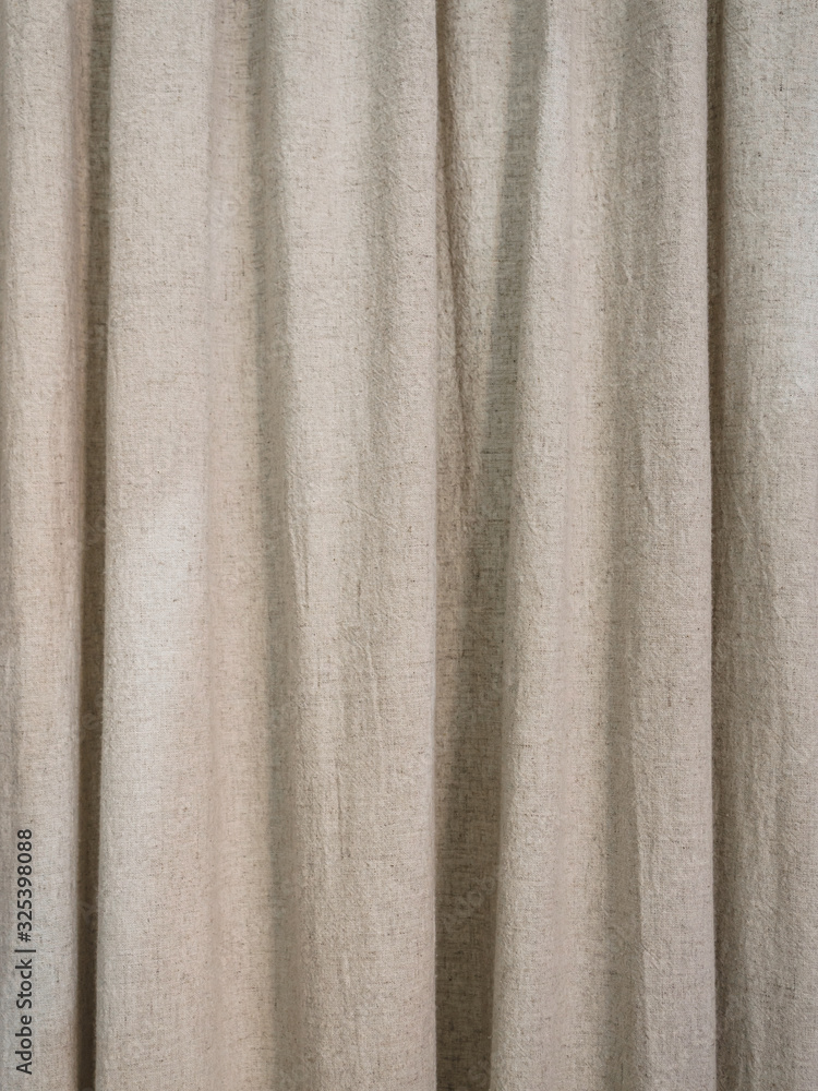 Beige curtains made of natural linen with many folds Beige curtains made of natural linen with many folds