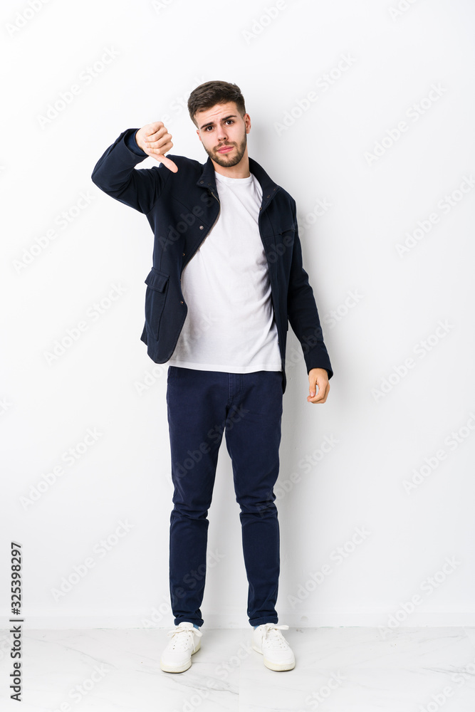Full body young caucasian man isolated showing a dislike gesture, thumbs down. Disagreement concept. Full body young caucasian man isolated showing a dislike gesture, thumbs down. Disagreement concept.