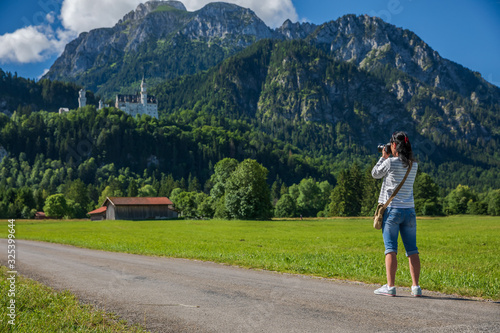 Canvas Print Female tourist taking photos Neuschwanstein Castle Bavarian Alps Germany