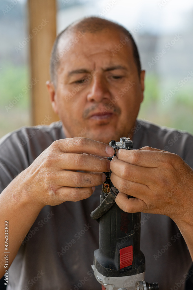 An unknown man fixing an electric tool