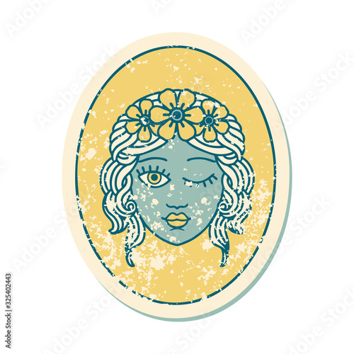 distressed sticker tattoo style icon of a maiden with crown of flowers winking
