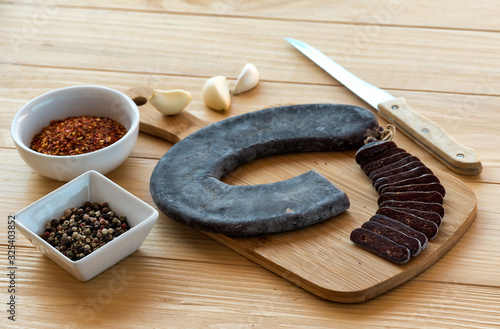 Cut Slices of Special Pirot horseshoe ironed sausage - Peglana Pirotska kobasica, made from veal, sheep and goat meat, with addition of garlic, mixed pepper, Crushed dried chili peppers and spices, on photo