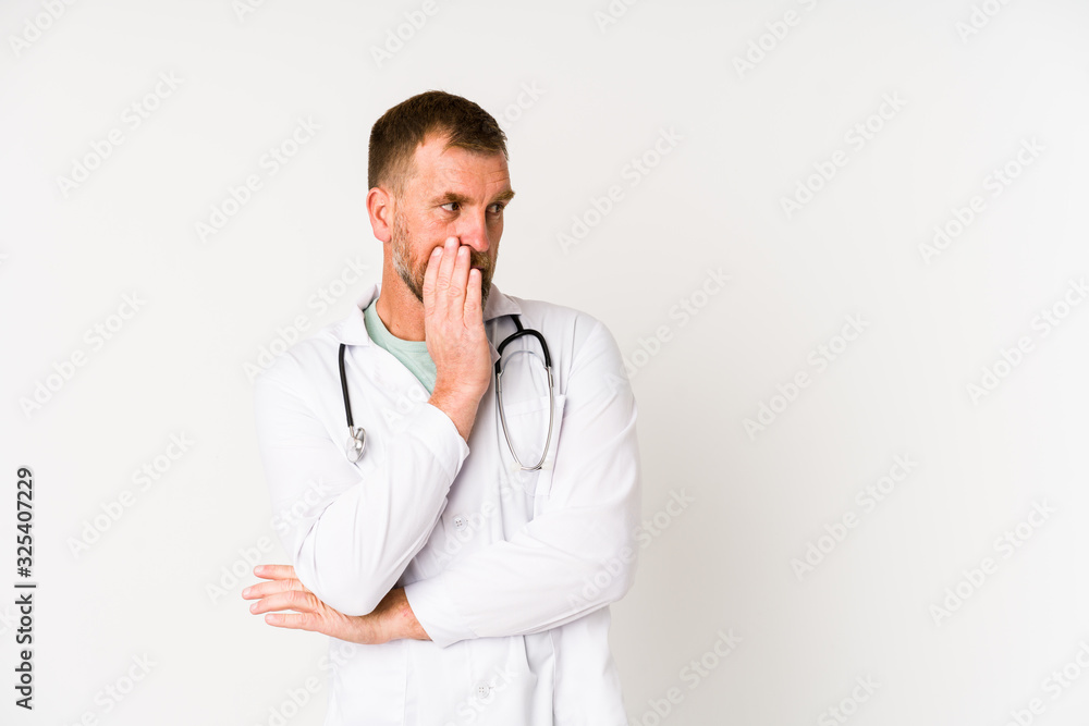 Senior doctor man isolated on white background is saying a secret hot braking news and looking aside Senior doctor man isolated on white background is saying a secret hot braking news and looking aside