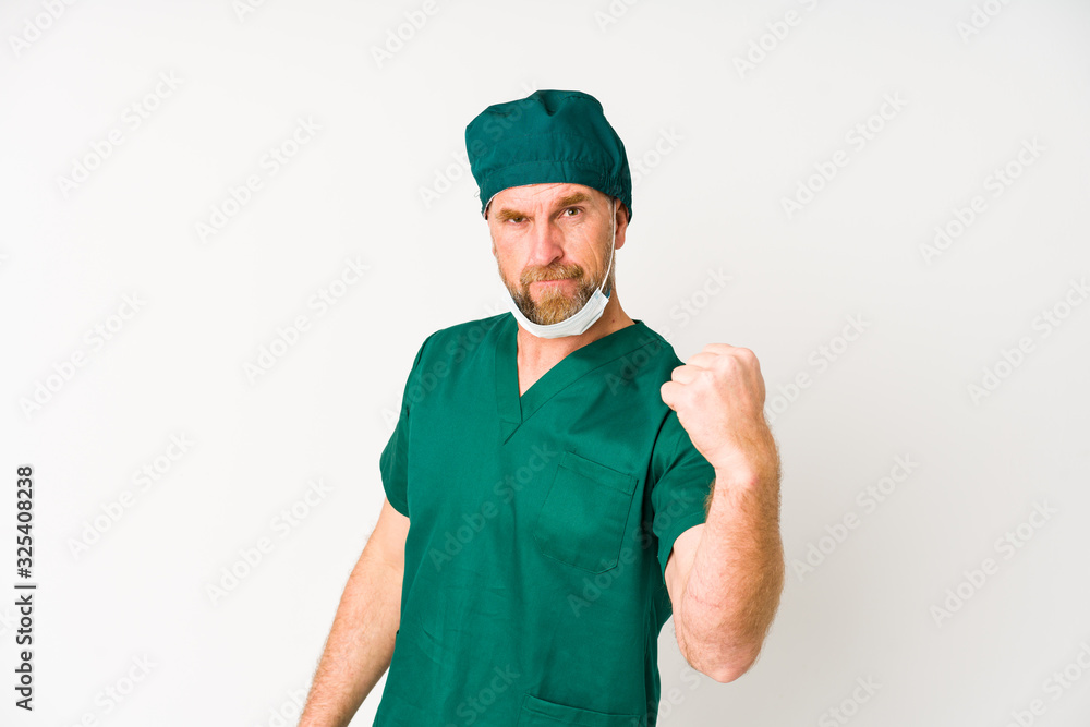 Surgeon senior man isolated on white background showing fist to camera, aggressive facial expression. Surgeon senior man isolated on white background showing fist to camera, aggressive facial expression.