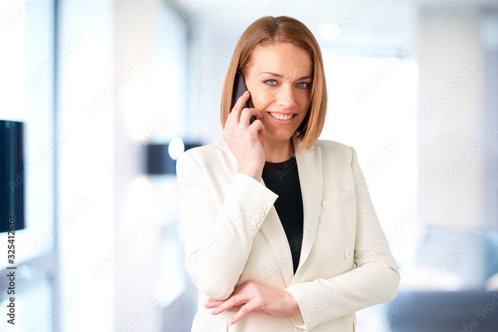 Middle aged businesswoman talking with somebody on her cell phone Middle aged businesswoman talking with somebody on her cell phone
