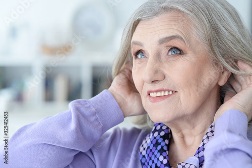 Portrait of happy beautiful senior woman posing at home