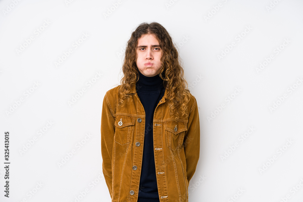Long hair man posing isolated blows cheeks, has tired expression. Facial expression concept. Long hair man posing isolated blows cheeks, has tired expression. Facial expression concept.