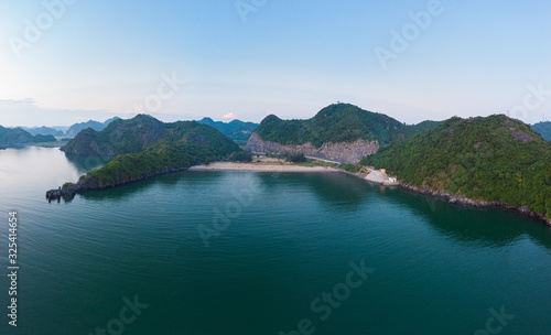 Aerial unique view Vietnam Cat Ba bay with floating fishing boats on sea  cloudscape tropical weather inspirational sunset  epic city skyline and skyscraper  scenic green mountain.