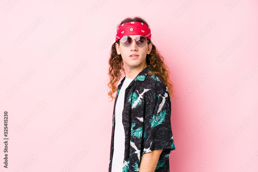 Young hippie caucasian man isolated looks aside smiling, cheerful and pleasant.