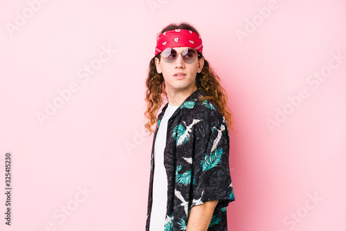 Young hippie caucasian man isolated looks aside smiling, cheerful and pleasant.