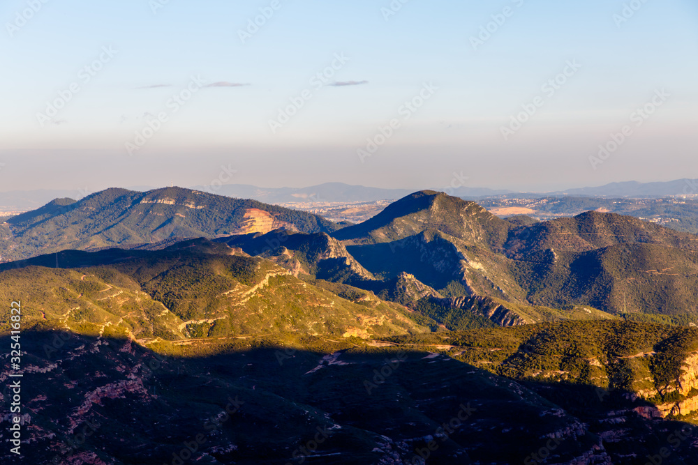 Evening in the mountains, the sun illuminates the peaks, and the lowlands are already in the shade. Spain