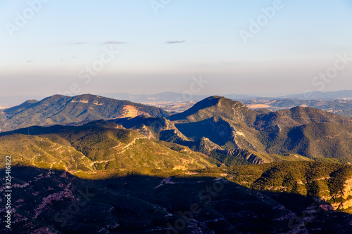 Evening in the mountains, the sun illuminates the peaks, and the lowlands are already in the shade. Spain © milanchikov