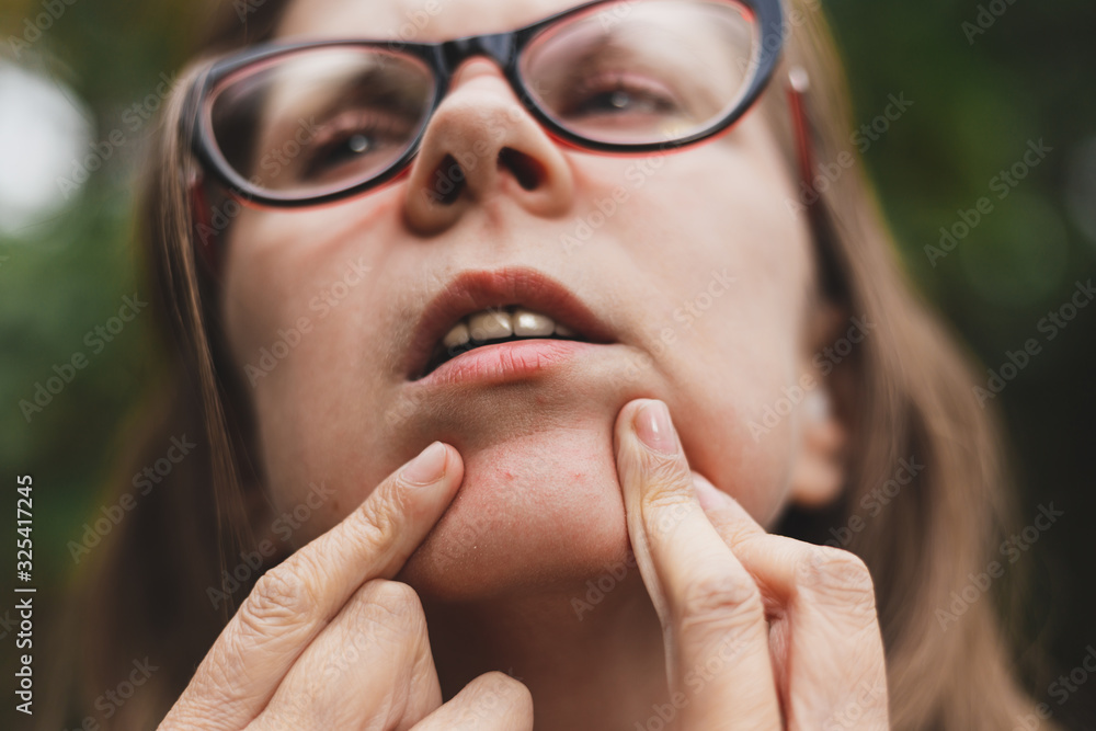 Woman checking skin of her face Woman checking skin of her face