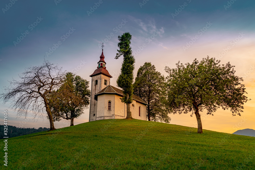 Beautiful colorful summer sunset in Slovenian Alp mountains with St Tomaz church. Travel destination Slovenia Beautiful colorful summer sunset in Slovenian Alp mountains with St Tomaz church. Travel destination Slovenia