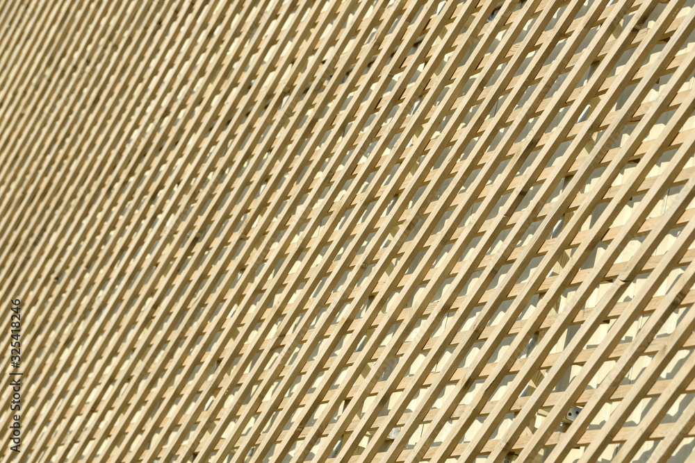 Wall of wooden planks. Lattice from a natural tree for weaving plants. Design for the decoration of buildings. Wood panel fence. Wall of wooden planks. Lattice from a natural tree for weaving plants. Design for the decoration of buildings. Wood panel fence.
