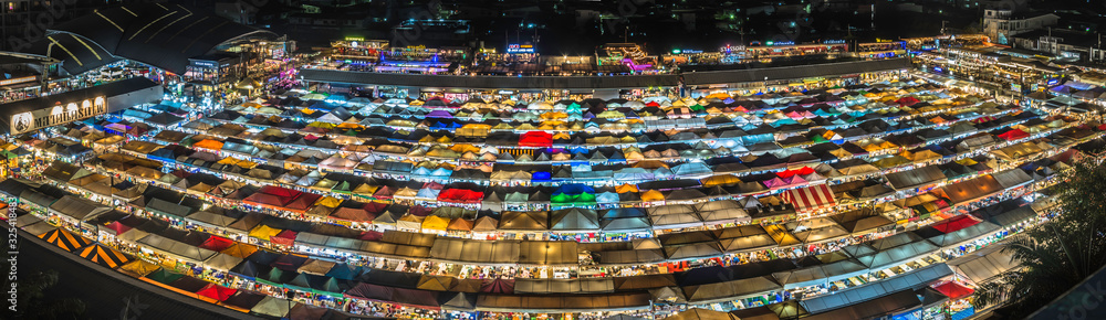 Panorama landscape view colorful of plastic roof of tent at ratchada train night market with dark sky of bangkok city. popular place for shopping at night.