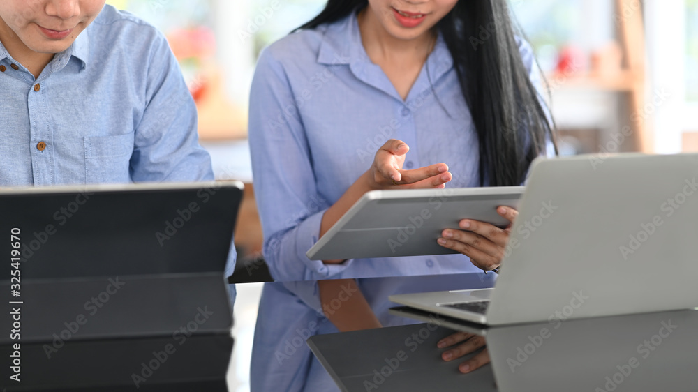 A business development team discussing about their business at the modern working desk. A business development team discussing about their business at the modern working desk.