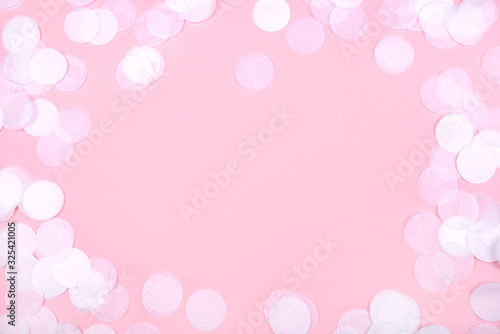 White confetti on pink background. Flat lay, top view. Copy space for text.
