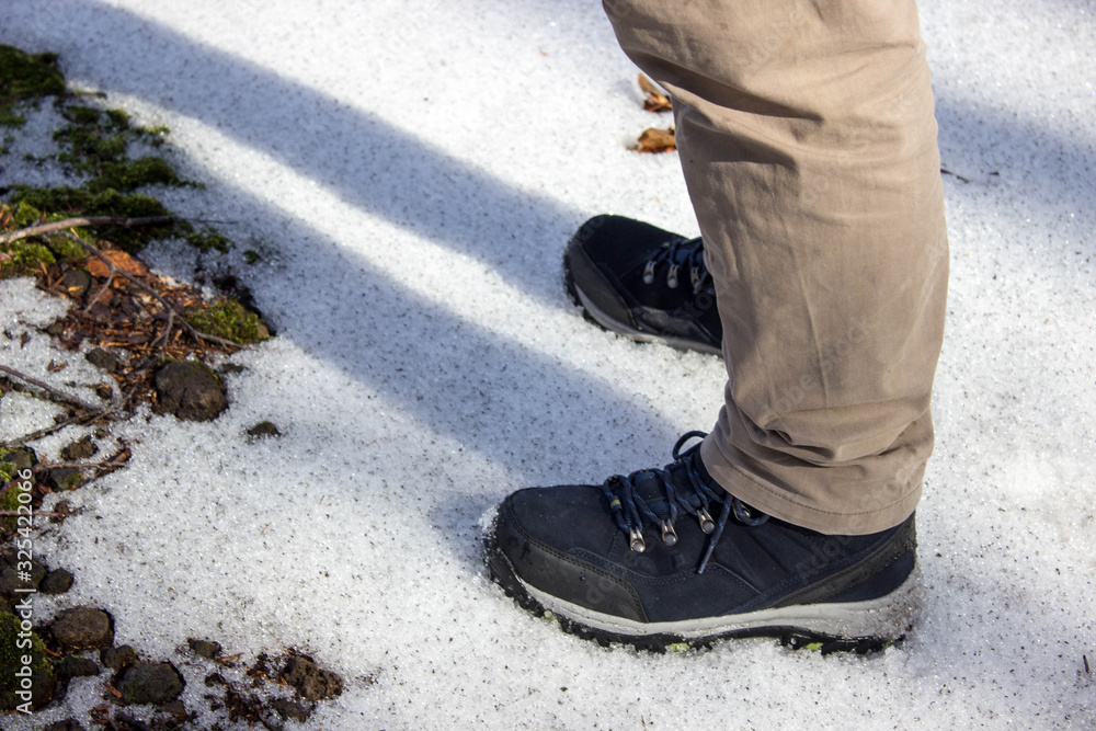 top view of trekking shoes on the lava stone background, male legs