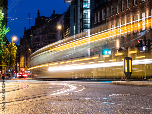 Manchester Metrolink tram captured at night in motion with a slow shutter outside of St Peter's Square