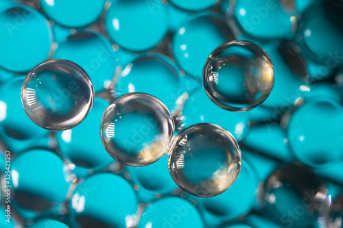 A macro shot of water beads on a blue light bed.
