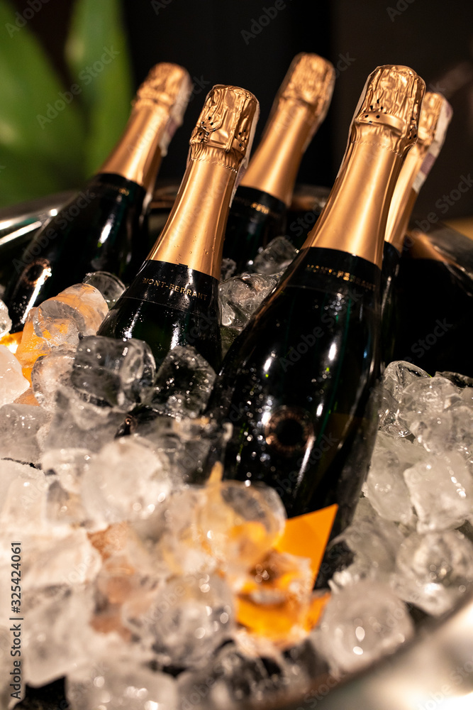 Bottles of champagne in cooler. Bottles in bucket of ice in the foreground. Selective focus
