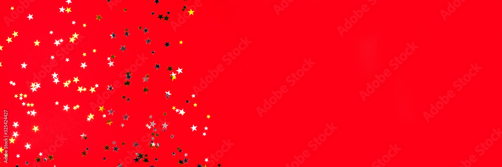 Golden and silver stars on red background. Flat lay, top view. Golden and silver stars on red background. Flat lay, top view.