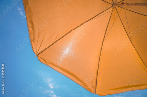 yellow umbrella on blue sky with clouds. Happy holiday vacation concept