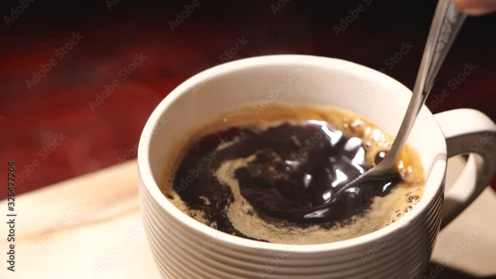 Stirring black coffee with spoon in slow motion Stirring black coffee with spoon in slow motion