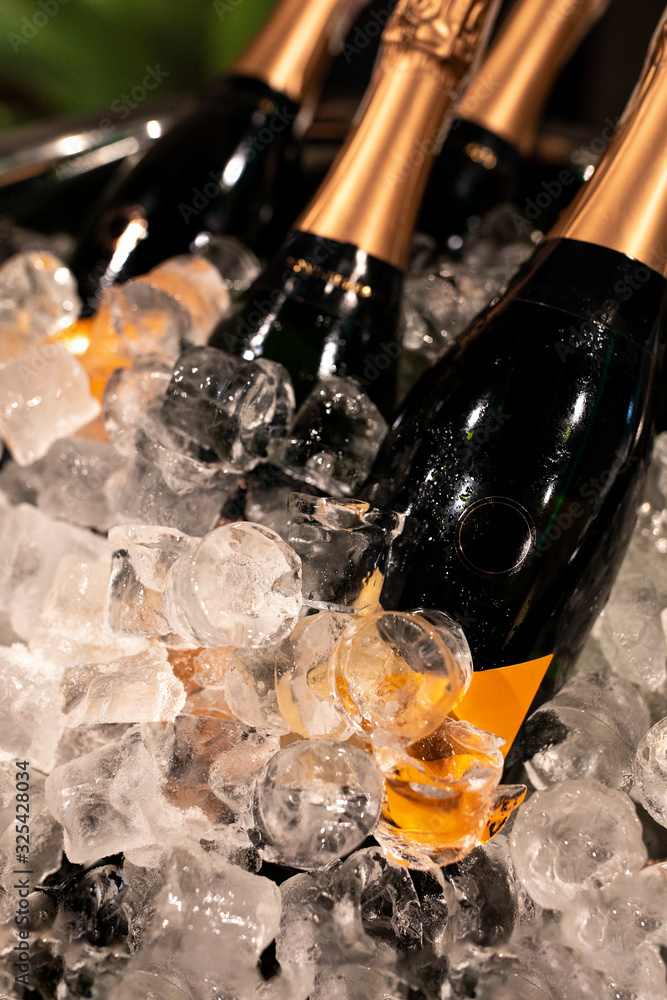 Bottles of champagne in cooler. Bottles in bucket of ice in the foreground. Selective focus