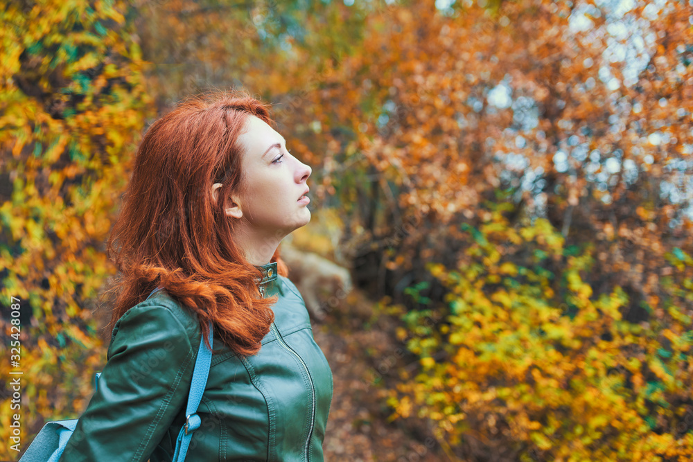 Young woman with autumn tree. A woman admires the autumn scenery in the orange forest. Young woman with autumn tree. A woman admires the autumn scenery in the orange forest.