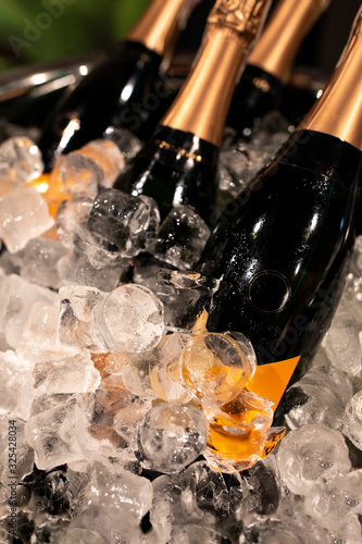 Obraz na płótnie Bottles of champagne in cooler. Bottles in bucket of ice in the foreground. Selective focus w salonie