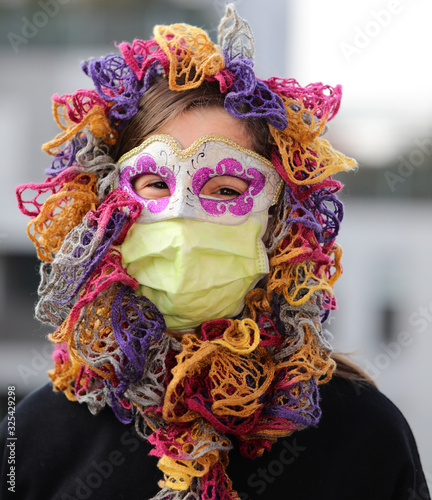 little girl with health mask and carnival mask for protection against the Virus crown photo