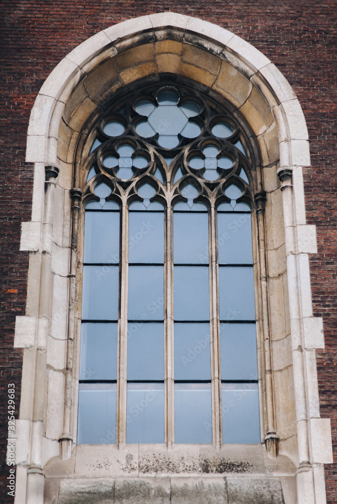 Old window with stained glass on facade of the building. Baroque and Gothic architecture. Church of St. Olga and Elizabeth. Lviv, Ukraine.