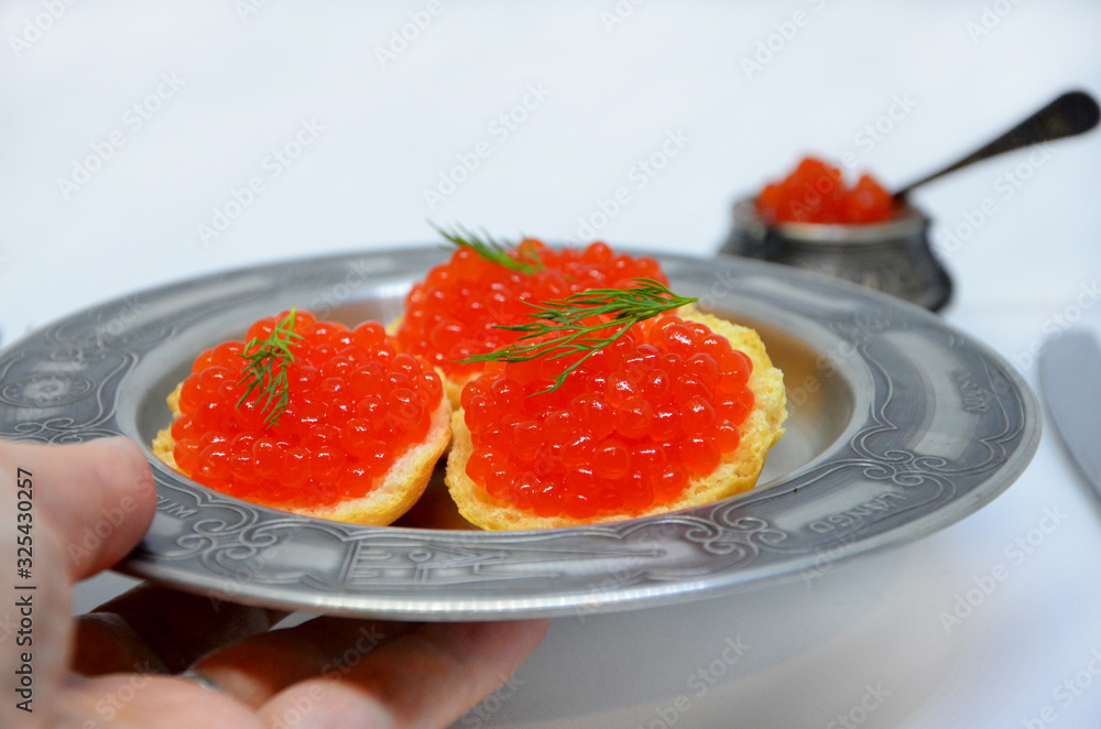 sandwich plate with caviar in hand