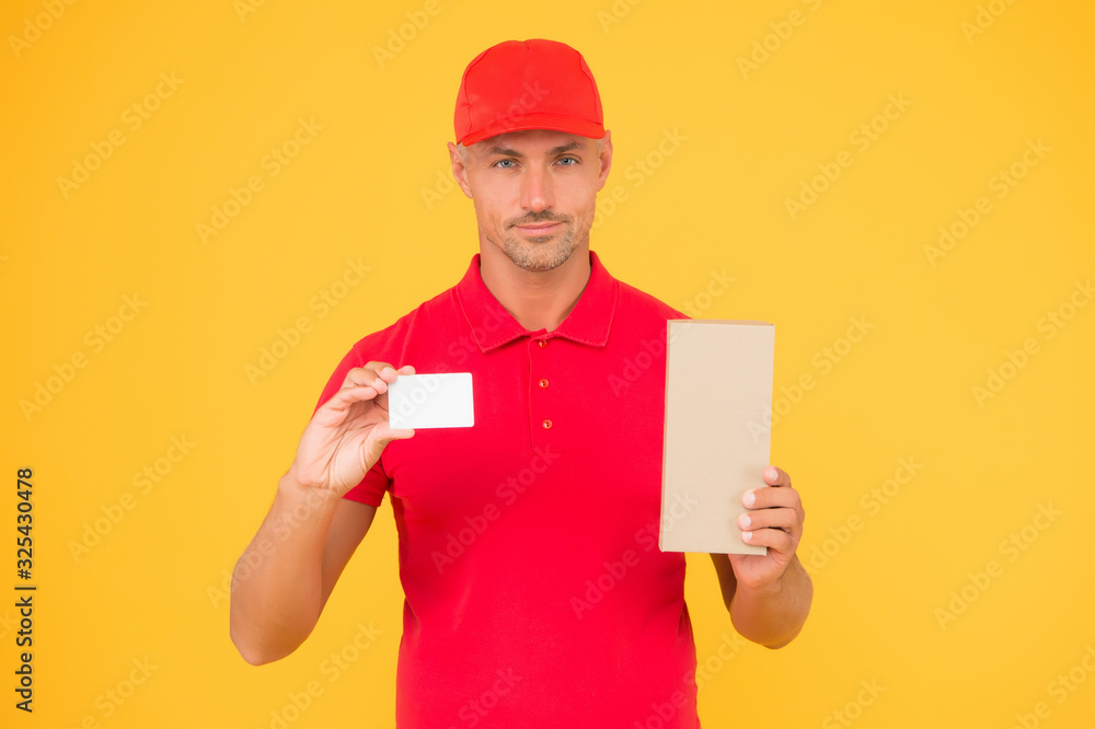 Get free discount card. Delivered to your destination. Service delivery. Courier and delivery. Postman delivery worker. Handsome man red cap yellow background. Delivering purchase. Business contact