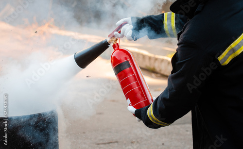 A man conducts exercises with a fire extinguisher. Fire extinguishing concept. Fire emergency incident