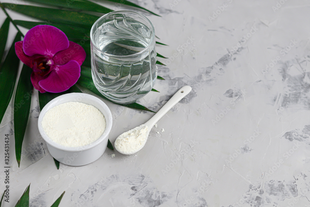 Collagen powder in a transparent bowl with a spoon for measuring quantity. Extra protein intake. Natural supplements for beauty and health. Collagen based plant concept. Flatlay, top view. Collagen powder in a transparent bowl with a spoon for measuring quantity. Extra protein intake. Natural supplements for beauty and health. Collagen based plant concept. Flatlay, top view.