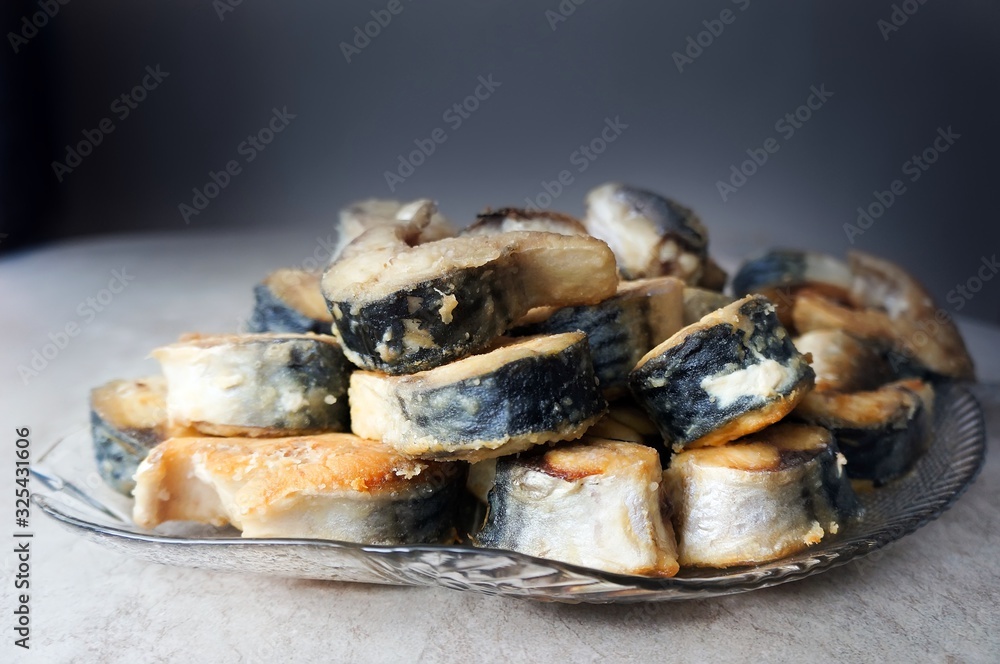Fried fish on a glass dish on a dark background Fried fish on a glass dish on a dark background